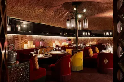 a restaurant with red and yellow chairs and tables at Hyatt Regency Casablanca in Casablanca