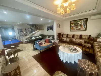 a living room with a couch and a table at Au Cœur Des Plages de Rabat in Oulad Kerroum