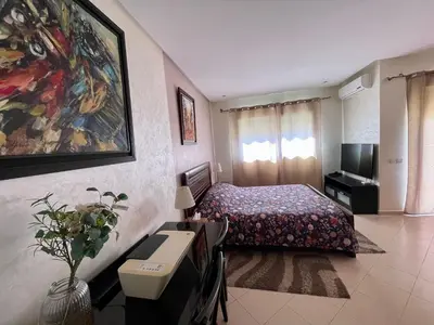 a hotel room with a bed and a television at Au Cœur Des Plages de Rabat in Oulad Kerroum