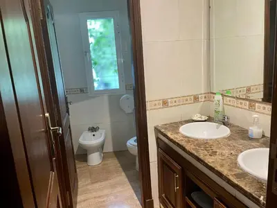 a bathroom with two sinks and a toilet and a window at Au Cœur Des Plages de Rabat in Oulad Kerroum
