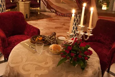 a table with two candles and flowers on it at Villa Des Ambassadors in Rabat