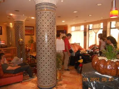 a lobby with a large column with people standing around at Hôtel Astrid in Casablanca