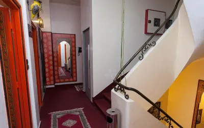 a hallway with a staircase with a red and yellow door at Hôtel Astrid in Casablanca