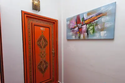 a wooden door next to a painting on a wall at Hôtel Astrid in Casablanca