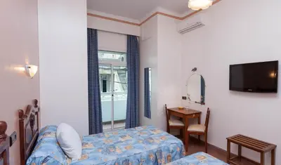 a bedroom with a bed and a table and a television at Hôtel Astrid in Casablanca