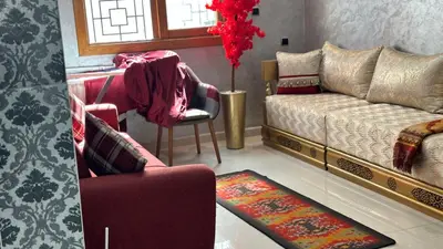 a living room with a couch and a chair at Joli appartement Casablanca ain sebaa in Casablanca