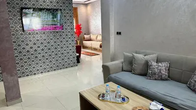 a living room with a couch and a table at Joli appartement Casablanca ain sebaa in Casablanca