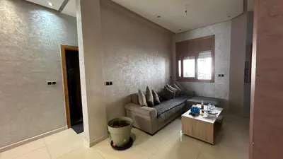 a living room with a couch and a coffee table at Joli appartement Casablanca ain sebaa in Casablanca