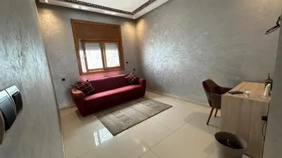 a living room with a red couch and a window at Joli appartement Casablanca ain sebaa in Casablanca