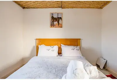 a bedroom with a bed with a horse picture on the wall at Gîte équestre Balade plage petit déjeuner au bord de la piscine in Azemmour