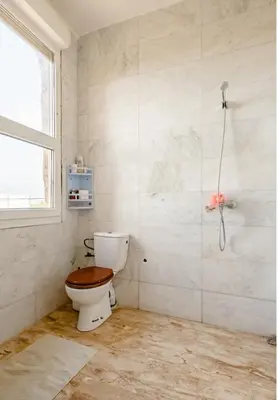 a bathroom with a toilet and a window at Gîte équestre Balade plage petit déjeuner au bord de la piscine in Azemmour