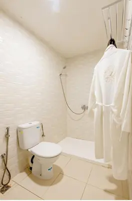 a white bathroom with a toilet and a shower at Gîte équestre Balade plage petit déjeuner au bord de la piscine in Azemmour
