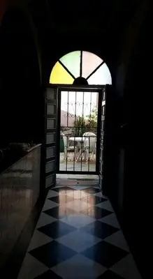 a dark room with a window and a checkered floor at Riad Nabila in Casablanca
