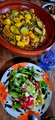 a bowl of food and a plate of vegetables on a table at Riad Nabila in Casablanca