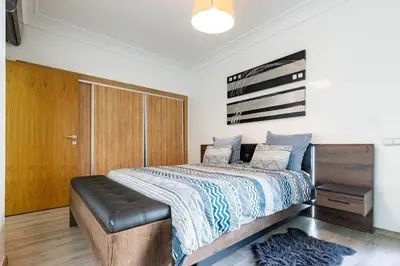 a bedroom with a bed with a black leather seat at Miramar Residence Beach in Mohammedia