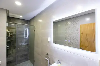 a bathroom with a shower and a sink and a mirror at Miramar Residence Beach in Mohammedia