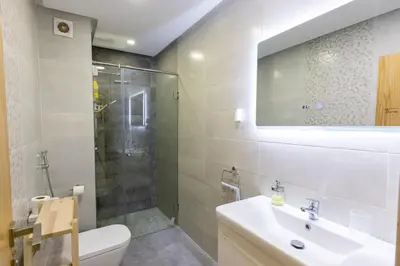 a bathroom with a toilet and a sink and a shower at Miramar Residence Beach in Mohammedia