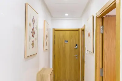a hallway with a wooden door and pictures on the wall at Miramar Residence Beach in Mohammedia