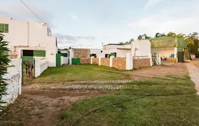a group of buildings with a grass field next to it at Elaaz Horse Farm in Azemmour