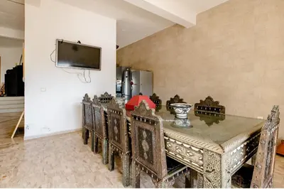 a dining room with a table and chairs and a tv at Elaaz Horse Farm in Azemmour