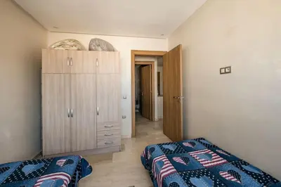 a bedroom with a bed and a dresser in it at Champs Elysee in Casablanca