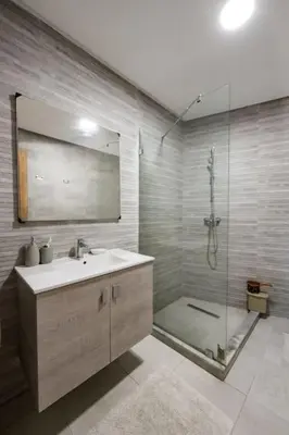 a bathroom with a sink and a shower with a mirror at Champs Elysee in Casablanca