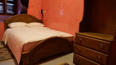 a bedroom with a wooden bed and a dresser at Ryad 91 in Casablanca