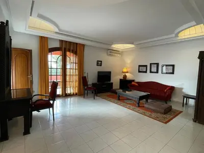 a living room with a red couch and a table at Dar Tahra in Casablanca