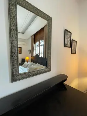 a mirror on the wall of a bedroom with a bed at Dar Tahra in Casablanca