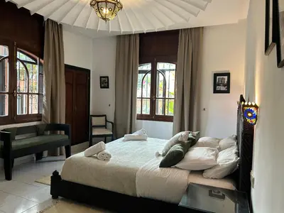 a bedroom with a large bed in a room with windows at Dar Tahra in Casablanca