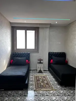 a living room with two beds and a window at le spatieux in Casablanca