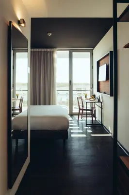 a hotel room with a bed and a table with a tableablish at ONOMO Airport Casablanca in Casablanca