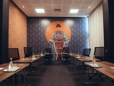 a room with tables and a large painting of a monkey at ONOMO Airport Casablanca in Casablanca