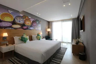 a bedroom with a large bed and a painting on the wall at Mid Town Hotel Casablanca in Casablanca