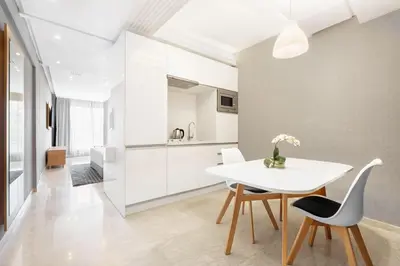 a kitchen and dining room with a white table and chairs at Mid Town Hotel Casablanca in Casablanca