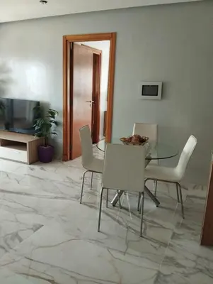 a dining room with a glass table and chairs at Belle-Vue sur Mer à Casa-Marina 9éme étage in Casablanca