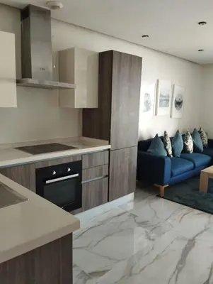 a kitchen with a blue couch in a living room at Belle-Vue sur Mer à Casa-Marina 9éme étage in Casablanca