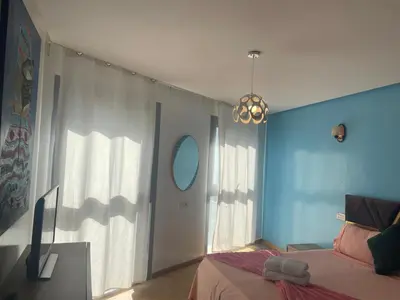 a bedroom with a bed and a blue wall at Belle-Vue sur Mer à Casa-Marina 9éme étage in Casablanca