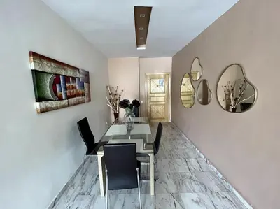 a dining room with a table and chairs and mirrors at Late&Early Flight cozy Apartment in Nouaseur