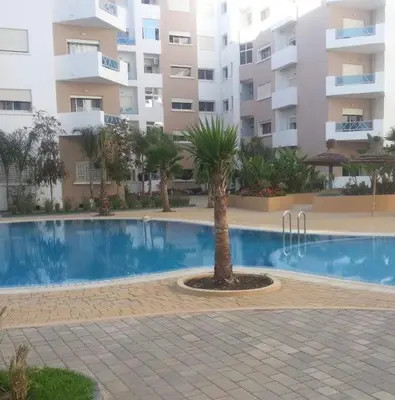 a palm tree in front of a building at Late&Early Flight cozy Apartment in Nouaseur