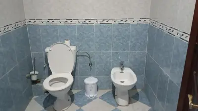 a blue tiled bathroom with a toilet and a bidet at Faridi vacancy appartment in Casablanca