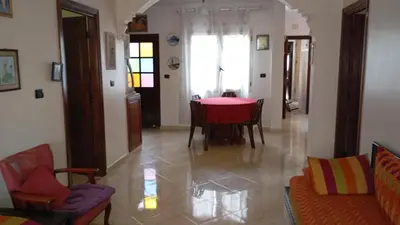 a living room with a red table and chairs at Faridi vacancy appartment in Casablanca