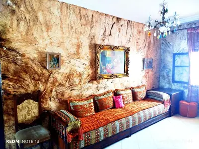 a living room with a couch against a stone wall at Appartement a casablanca in Casablanca