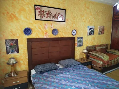 a bedroom with a bed and a chair and plates on the wall at Appartement a casablanca in Casablanca
