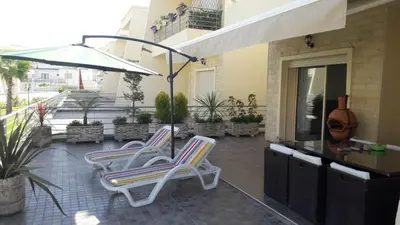 two lounge chairs and an umbrella on a patio at Dar Lazraq in Sidi Rahal