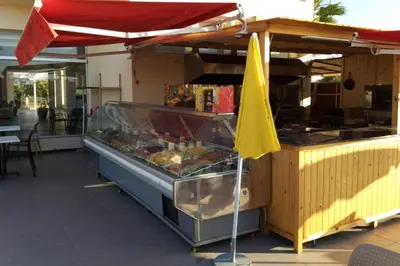 a food stand with a yellow umbrella next to it at Magnifique Villa a Savannah Beach in Sidi Rahal