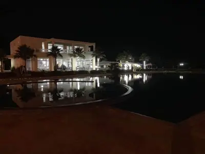 a house at night with a pool in front of it at Magnifique Villa a Savannah Beach in Sidi Rahal