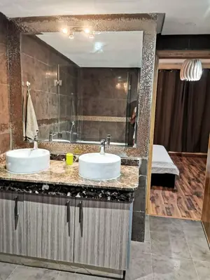 a bathroom with two sinks and a large mirror at Magnifique Villa a Savannah Beach in Sidi Rahal