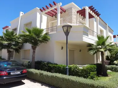 a house with a car parked in front of it at Magnifique Villa a Savannah Beach in Sidi Rahal