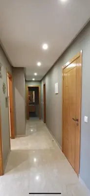 an empty hallway with a wooden door in a room at Hadil Room in Rabat
